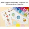 A collection of sealing wax beads and finished wax seals on cards. Náhled obrázku produktu