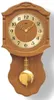 A wooden pendulum clock with a gold-colored face and pendulum. Produktbild-Vorschau