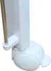 Close-up view of the white caster wheel and support structure of a baby crib or bed. Produktbild-Vorschau