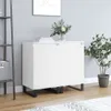A white sideboard with black legs is shown in a room with a plant and a ladder shelf. Náhled obrázku produktu