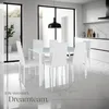 A modern dining room with a white table and chairs, a black pendant light, and a view of an outdoor patio through large glass doors. Náhled obrázku produktu
