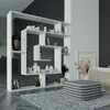 A modern white shelving unit filled with decorative items and books, placed in a living room setting with a pouf and rug. Anteprima dell’immagine prodotto