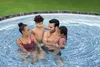 A family is enjoying themselves in an inflatable swimming pool. Anteprima dell’immagine prodotto
