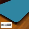 A close-up view of a teal-colored fitted sheet on a bed, with a wooden floor and a dresser visible in the background. A logo is present in the bottom left corner. Produktbild-Vorschau