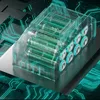 A transparent casing holding multiple green batteries, placed on a surface with glowing blue circuit board patterns. Produktbild-Vorschau