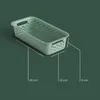 A green storage basket with dimensions indicated by lines and text. Produktbild-Vorschau