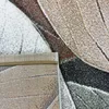 A close-up view of a rug with a leaf pattern. Voir les images du produit
