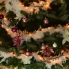 A close-up view of a decorated Christmas tree with lights, ornaments, and tinsel. Produktbild-Vorschau