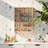 A wooden display case filled with small animal figurines is mounted on a wall with a geometric pattern. In front of the display case, on a white desk, are children's building blocks and a toy train. Produktbild-Vorschau