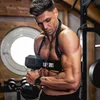 A man is working out in a gym, lifting a dumbbell. Náhľad obrázku produktu