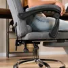 A person sitting in a gray office chair, showing the chair's features. Produktbild-Vorschau