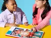 Two young girls are playing the Operation board game. Podgląd zdjęcia produktu