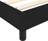 A close-up, low-angle shot of a black fabric bed frame with wooden slats inside. Voir les images du produit