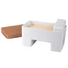 A white butter dish with a block of butter inside and a wooden lid next to it, on a white background. Podgląd zdjęcia produktu