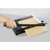 A hand is using a paper cutter to cut a piece of paper. Produktbild-Vorschau