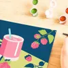 A close-up view of a paint-by-numbers kit with a hand holding a paintbrush. Produktbild-Vorschau