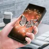 A hand holding a smartphone case with a butterfly and diamond pattern. Produktbild-Vorschau