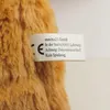 A close-up of a tag attached to a brown, furry object, likely a teddy bear. Anteprima dell’immagine prodotto