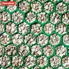 A close-up view of a green hexagonal grid filled with small stones and pebbles. Produktbild-Vorschau