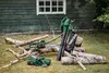Garden tools, including a leaf blower and two chainsaws, are arranged on the grass in front of a wooden shed with a window. Produktbild-Vorschau