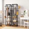Two industrial-style clothing racks with shelves are shown in a room, next to a vanity table and mirror. Clothes and accessories are displayed on the racks. Produktbild-Vorschau