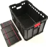 A black plastic storage crate with red handles and two folded black plastic inserts with red elastic straps, shown on a white background. Voir les images du produit