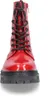 A close-up, front-facing view of a red patent leather boot with black laces and a thick black sole. Produktbild-Vorschau