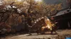 A mythical creature with golden glowing parts is fighting in a forest with autumn foliage and a traditional building in the background. Produktbild-Vorschau