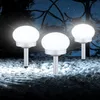 Three solar garden lights are illuminated at night, placed among white pebbles in a garden setting. Produktbild-Vorschau