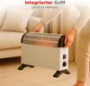 A person is holding a white electric heater with black accents in a living room setting. Produktbild-Vorschau