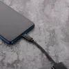 A close-up shot of a smartphone being charged with a USB-C to 3.5mm audio adapter cable. Produktbild-Vorschau