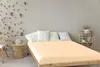 A bedroom scene with a bed, side table, and chair. Produktbild-Vorschau