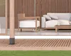 An outdoor living space with wooden decking, a wooden chair and sofa with white cushions, and a wooden coffee table. Náhled obrázku produktu
