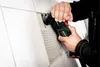 A person is using a Metabo multitool to remove grout from between tiles. Náhľad obrázku produktu