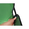 A hand holding a green fabric product with a black frame and a black plastic part. Voir les images du produit