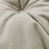 A close-up view of a tufted beige fabric cushion, showing the texture and stitching. Produktbild-Vorschau