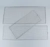 Three stainless steel grill racks are arranged on a light gray surface. Náhled obrázku produktu