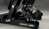 Close-up view of racing simulator pedals, showing the spring mechanism and a pressure force indicator. Produktbild-Vorschau