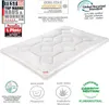 A white quilted blanket is shown on a white background, with various certifications and labels around it. Produktbild-Vorschau