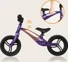 A purple balance bike with black wheels and seat, shown from the side. An inset image shows a hand holding the handlebars. Produktbild-Vorschau