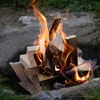 A close-up shot of a campfire with burning wood and cardboard. Produktbild-Vorschau