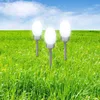 Three solar garden lights are placed in a lush green field under a blue sky with white clouds. Produktbild-Vorschau
