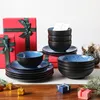 A set of tableware is displayed on a table with Christmas decorations and gift boxes. Voir les images du produit