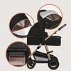 A black and gold stroller with close-up insets showing details of the canopy and storage. Produktbild-Vorschau