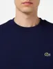 Close-up of a man wearing a navy blue Lacoste sweatshirt. Anteprima dell’immagine prodotto