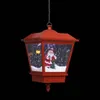 A red Christmas lantern with a Santa Claus figurine inside, suspended by a chain against a black background. Náhľad obrázku produktu