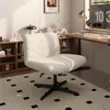 A white fluffy office chair is placed in a home office setting with a wooden desk and shelves. Produktbild-Vorschau