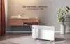 A bathroom setting with a vanity, sink, and a white electric heater with a towel draped over it. Produktbild-Vorschau
