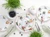 A flat lay of a fruit-themed dinnerware set with blueberries and greenery. Náhľad obrázku produktu