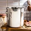 A stainless steel smoker with sausages and ham on a wooden table. Produktbild-Vorschau